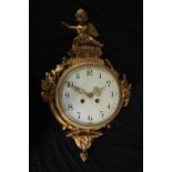 A Rococo cartel style gilt metal clock mounted with a cherub. H.46 W.27cm.