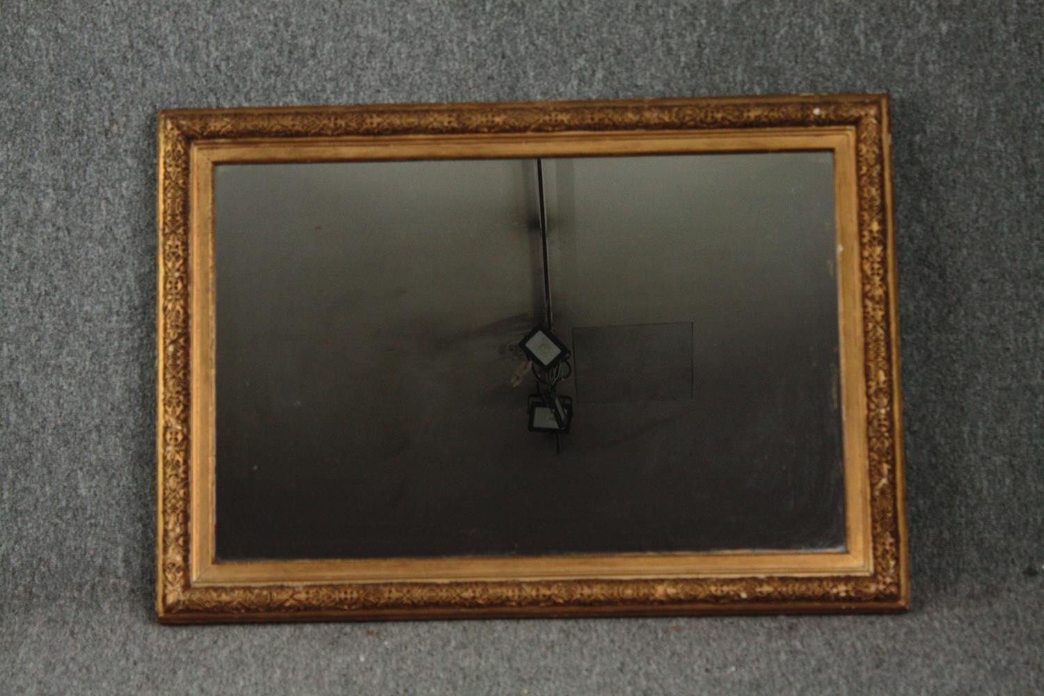 A 19th century gilt and gesso framed wall mirror with replacement plate. H.65 W.90cm.