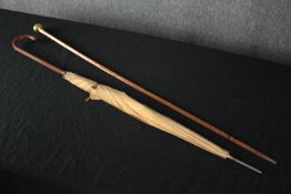 An umbrella and cane. The cane with a rounded brass handle. The umbrella is probably 1950s. L.