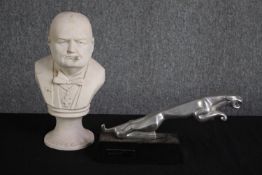 A metal Jaguar bonnet motif on a wooden plinth and a bust of Winston Churchill. H.31cm. (largest)