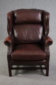 Wing back armchair, Georgian style leather upholstered on mahogany supports.