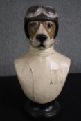 A moulded polychrome dog bust in vintage style racing driver gear. Modern. H.51cm.