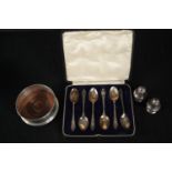 A collection of silver, including a silver and oak wine coaster, a cased set of silver tea spoons