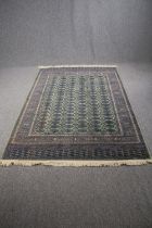 Carpet, woollen Bokhara style with repeating gul motifs on a sage ground. L.230 W.151cm.