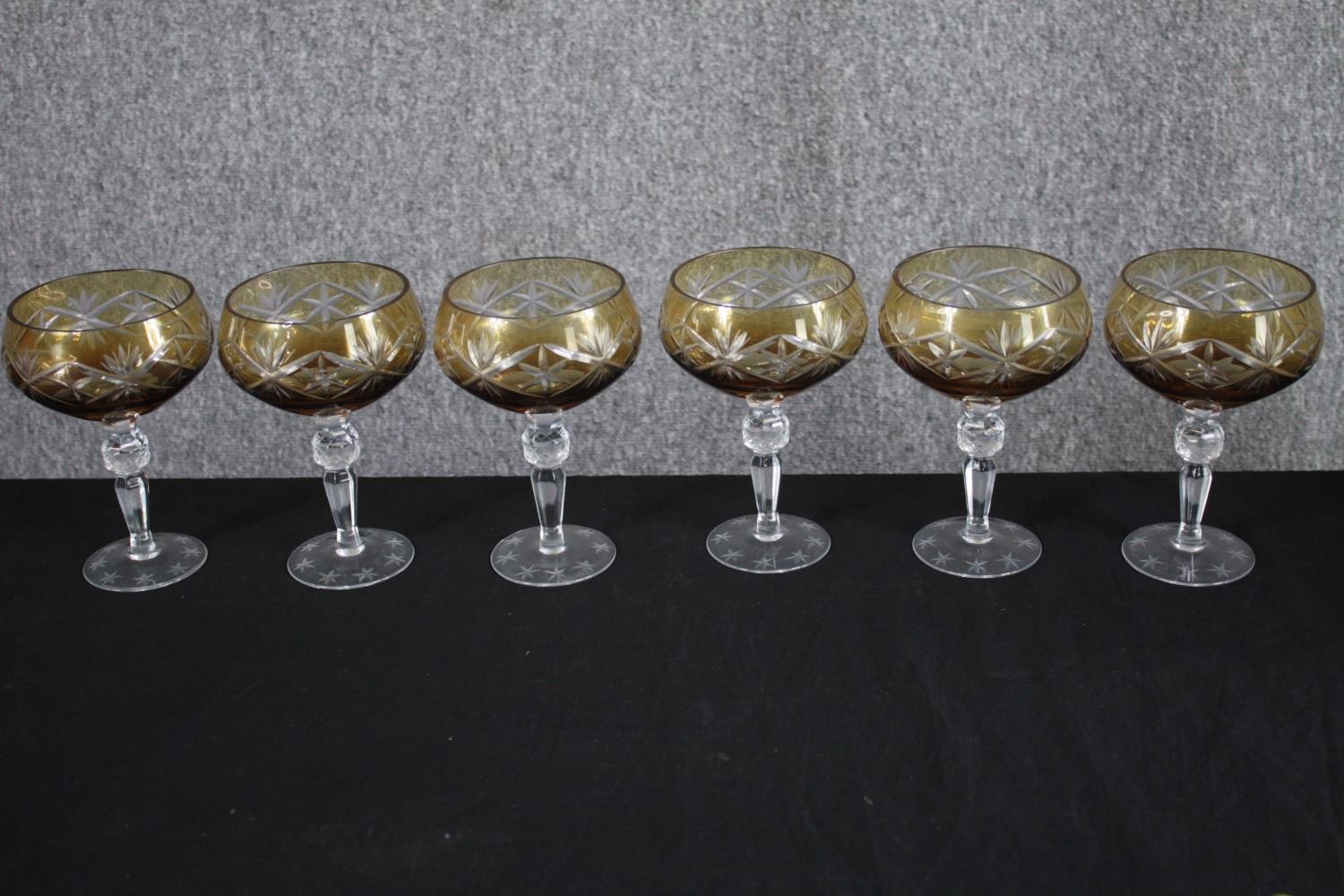 A set of six amber cut to clear stemmed wine glasses with star design. H.16cm. (each)
