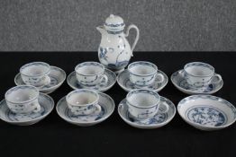 An incomplete coffee set made up of seven cups and saucers, a coffee pot and a loose saucer. H.17cm.