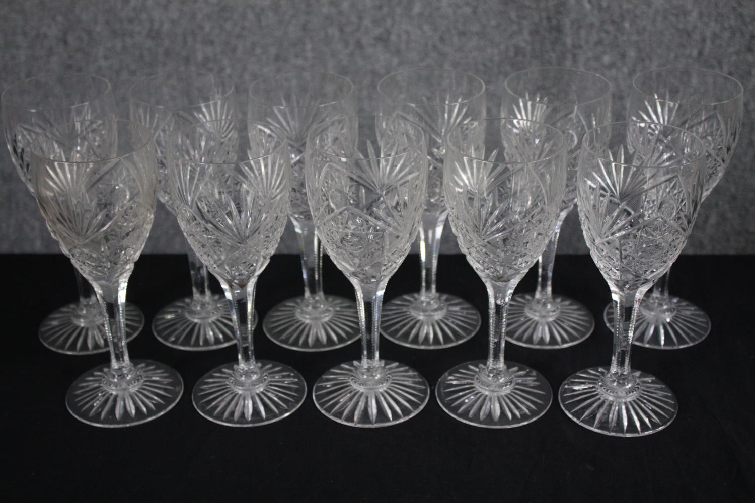 Eleven stemmed wine glasses. Cut crystal with star bases. H.20cm. (each)