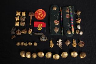 A mixed collection of military brass buttons, badges, epaulettes and medal ribbons. Includes a badge