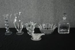 A mixed collection of glass including a decanter, candlestick and bowls one of which is in the shape