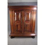 An early 19th century North European panelled chestnut armoire with engraved brass escutcheons on
