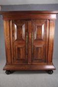 An early 19th century North European panelled chestnut armoire with engraved brass escutcheons on