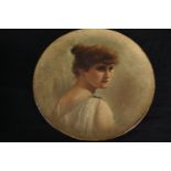 A painted wall plate with a portrait of a young women. Unsigned. Dia.29cm.
