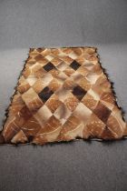 A rug from diagonal sectioned animal hide. L.240 W.145cm.