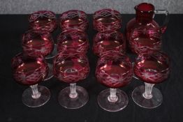 Eleven Victorian Cranberry glasses and jug. H.15cm. (each)