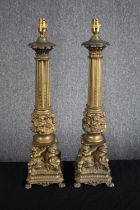 A matching pair of ornate brass pillar lamp stands supported by cherubs. H.63cm. (each)