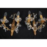 A pair of early 20th century cut crystal twin branch gilt metal wall sconces. H.32cm (each)