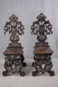 A pair of 19th century Italian carved oak Sgabello chairs. H.121cm. (Some carving missing as seen).