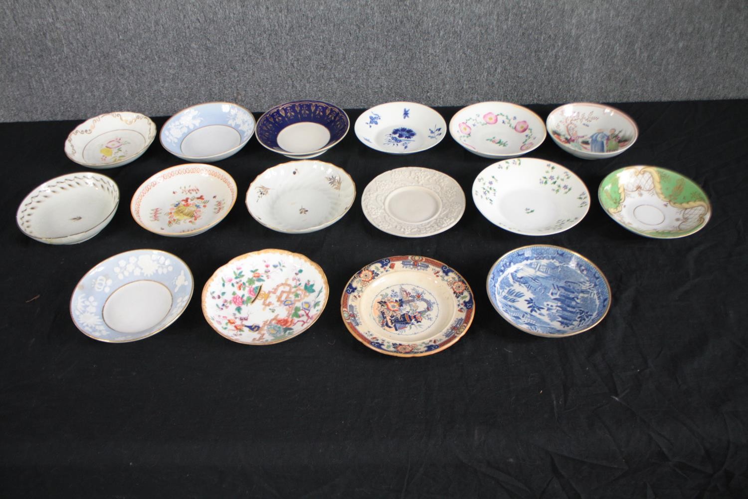 An assortment of 19th century hand painted saucers and side plates, including a dish with Chinese