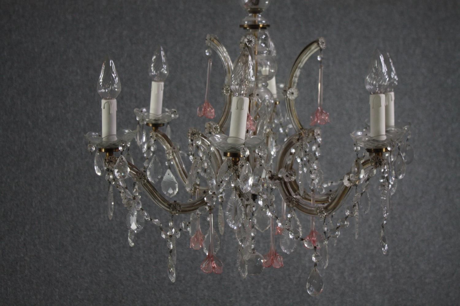 A Murano glass chandelier with six brass branches. Decorated with crystal swags, pale pink glass