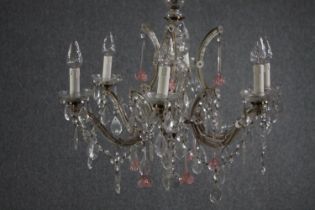 A Murano glass chandelier with six brass branches. Decorated with crystal swags, pale pink glass