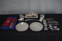 A mixed silver plate cutlery collection, place mats, a butter dish. Includes a carving set and