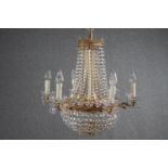 A French brass basket chandelier decorated with hanging crystal swags and beads of glass. H.75 Dia.