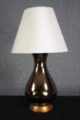 A table lamp mounted with twin light fittings and a bronze glaze. Twentieth century. H.73cm.