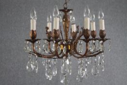 A French foliate design chandelier with seven branches. Brass decorated with hanging tear drop glass