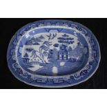 A large blue and white Chinese platter decorated with a pagoda and garden scene. Early to mid
