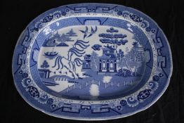 A large blue and white Chinese platter decorated with a pagoda and garden scene. Early to mid