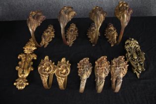 A collection of nine baroque style brass curtain (set of four, a pair and three) tie backs, a door