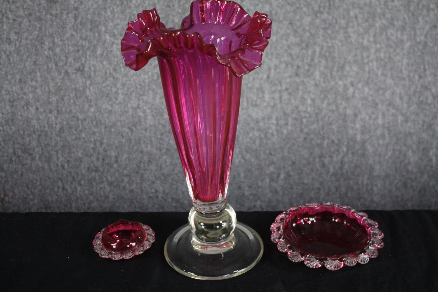 A Victorian decorative Cranberry glass trumpet vase with with ruffled edge and two small Cranberry