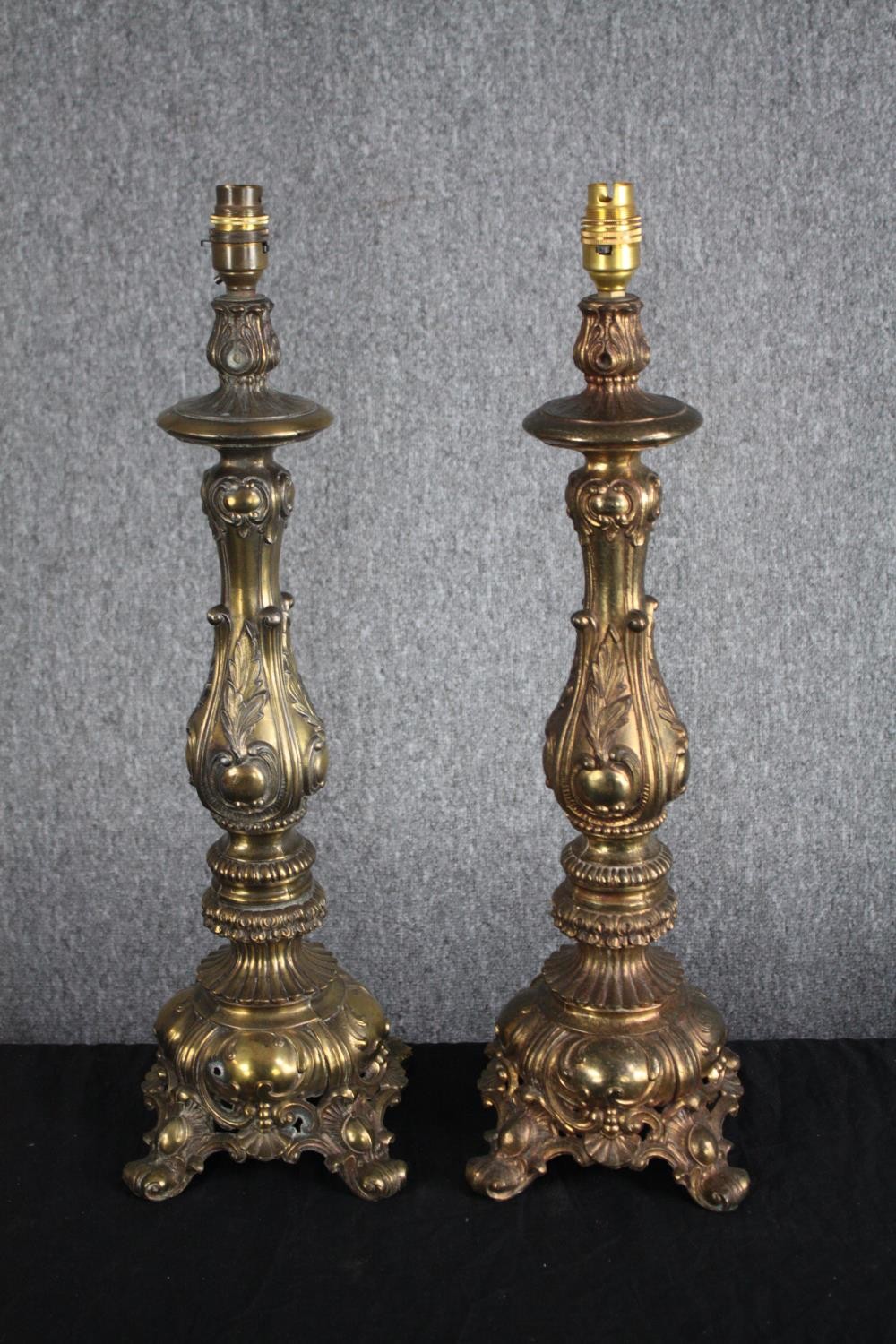 A pair of large casts brass lamps with four legged pedestals and raised Rococo revival style