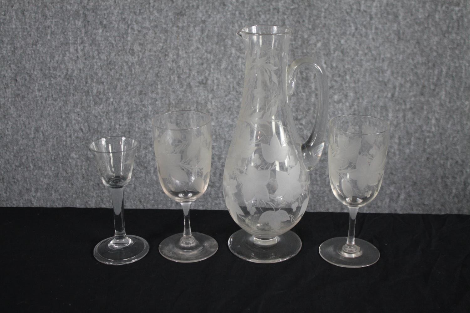Two etched Victorian wine glasses with etched foliate and fruit design with a matching wine jug