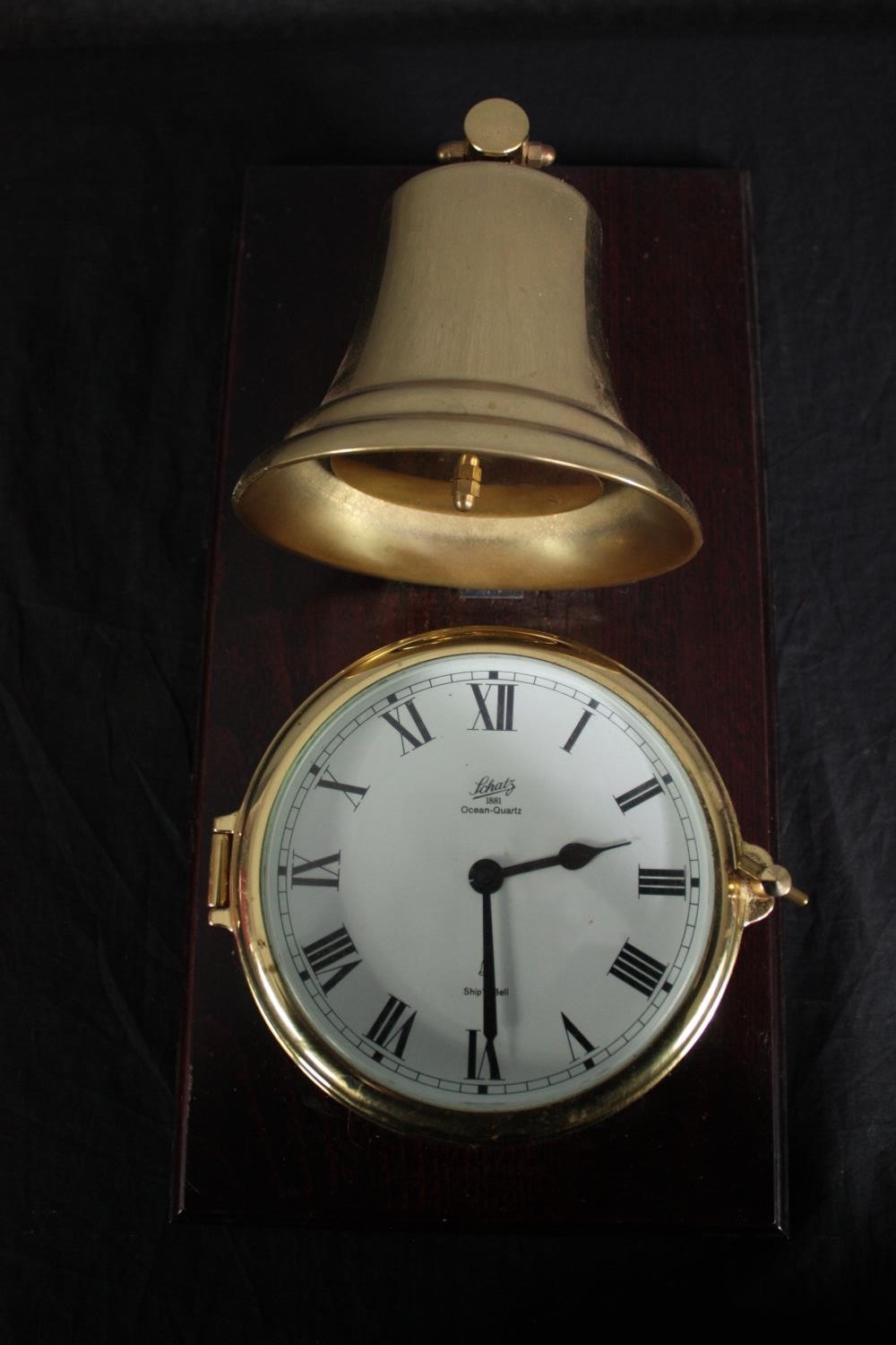 A brass cased Schatz clock with a bell mounted above. Ocean Quartz. H.42 W.22cm.