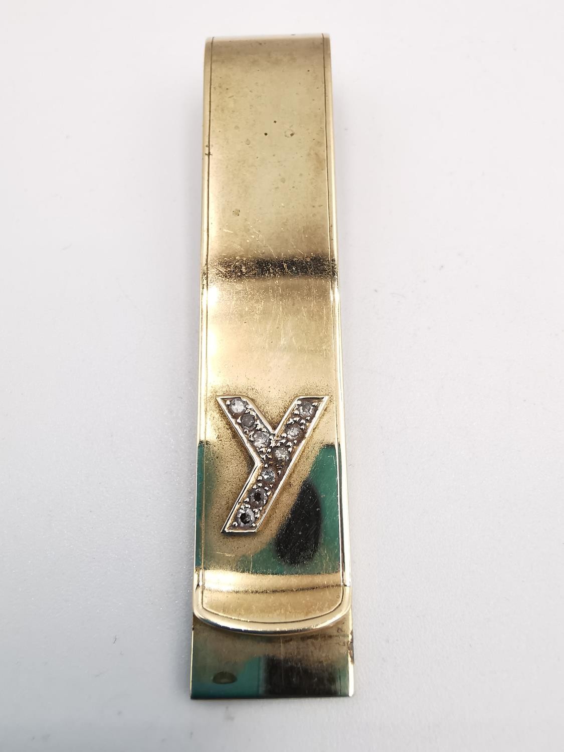 A yellow metal (tests as 9ct) yellow gold and diamond money clip. The clip adorned with the letter Y - Image 3 of 4