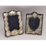 Two Victorian style repousse silver easel picture frames, one with a heart shaped picture cut out.