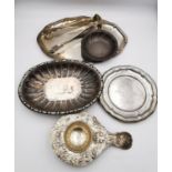 A collection of silver and white metal items, including a pair of sugar tongs with engraved