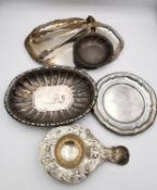 A collection of silver and white metal items, including a pair of sugar tongs with engraved