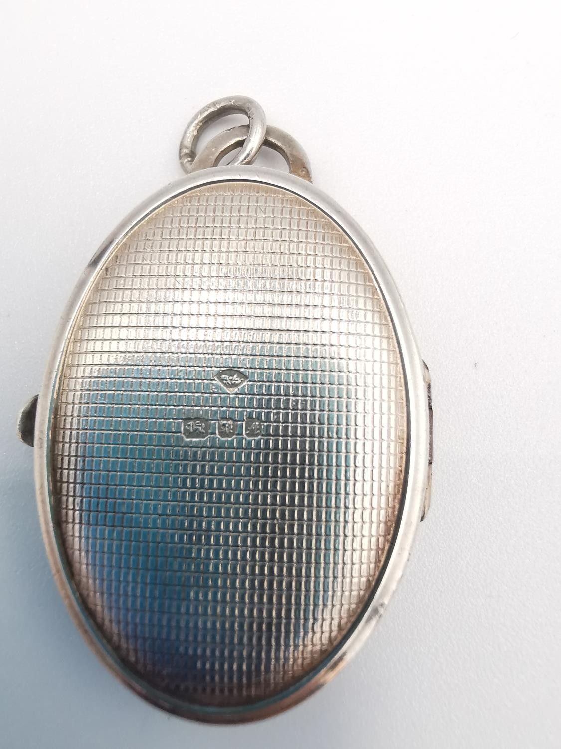 A heavy sterling silver oval locket with stylised scrolling foliate design with cross hatch design - Image 8 of 8