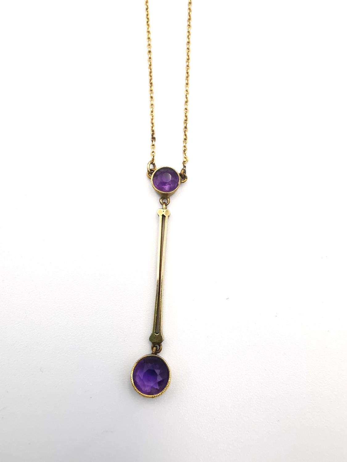 A 9ct yellow gold and amethyst drop pendant necklace. Set with two round mixed cut amethysts, the - Image 2 of 6