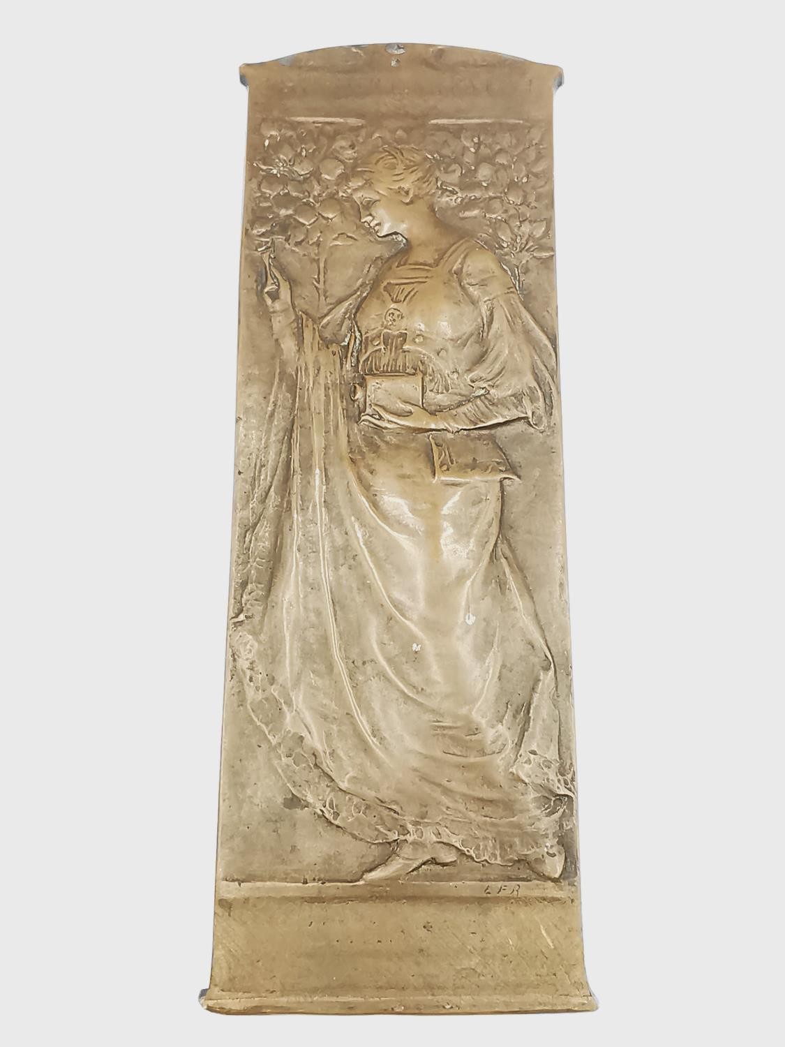 An Art Nouveau bronze relief plaque of a lady in flowing dress holding a magic lantern among blossom