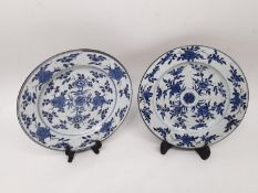 A pair of blue and white Kangxi period hand painted floral and foliate design plates. Unglazed foot.