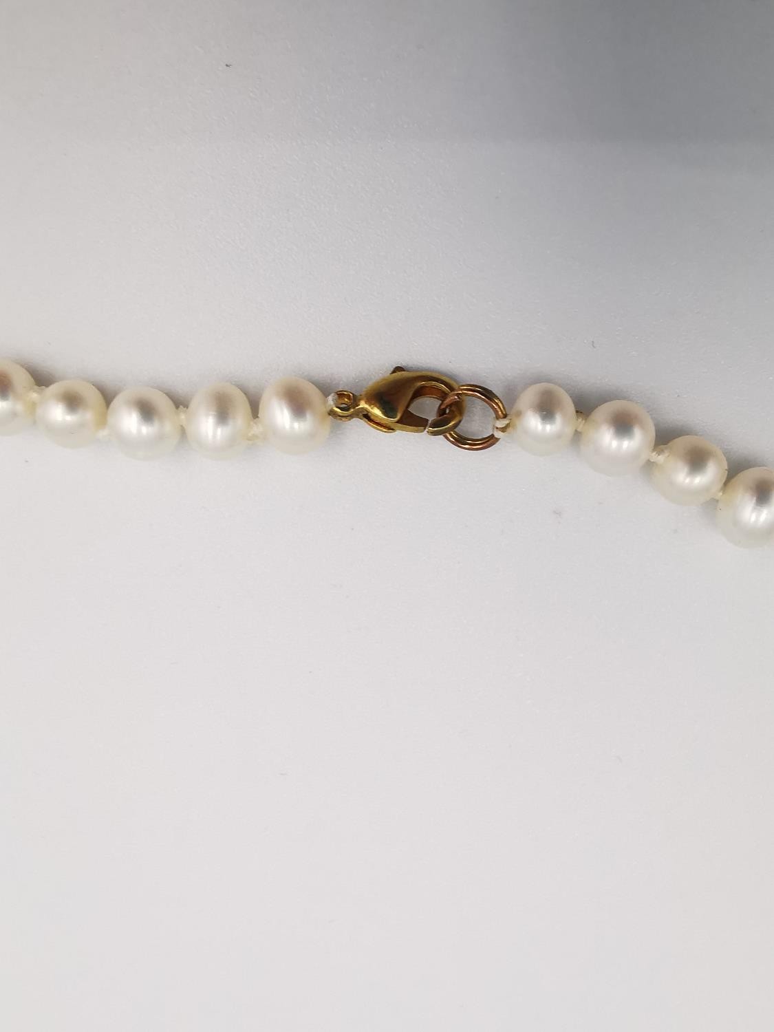 Two knotted white cultured pearl necklaces. One necklace with a 9ct bow shaped hook and push - Image 10 of 10