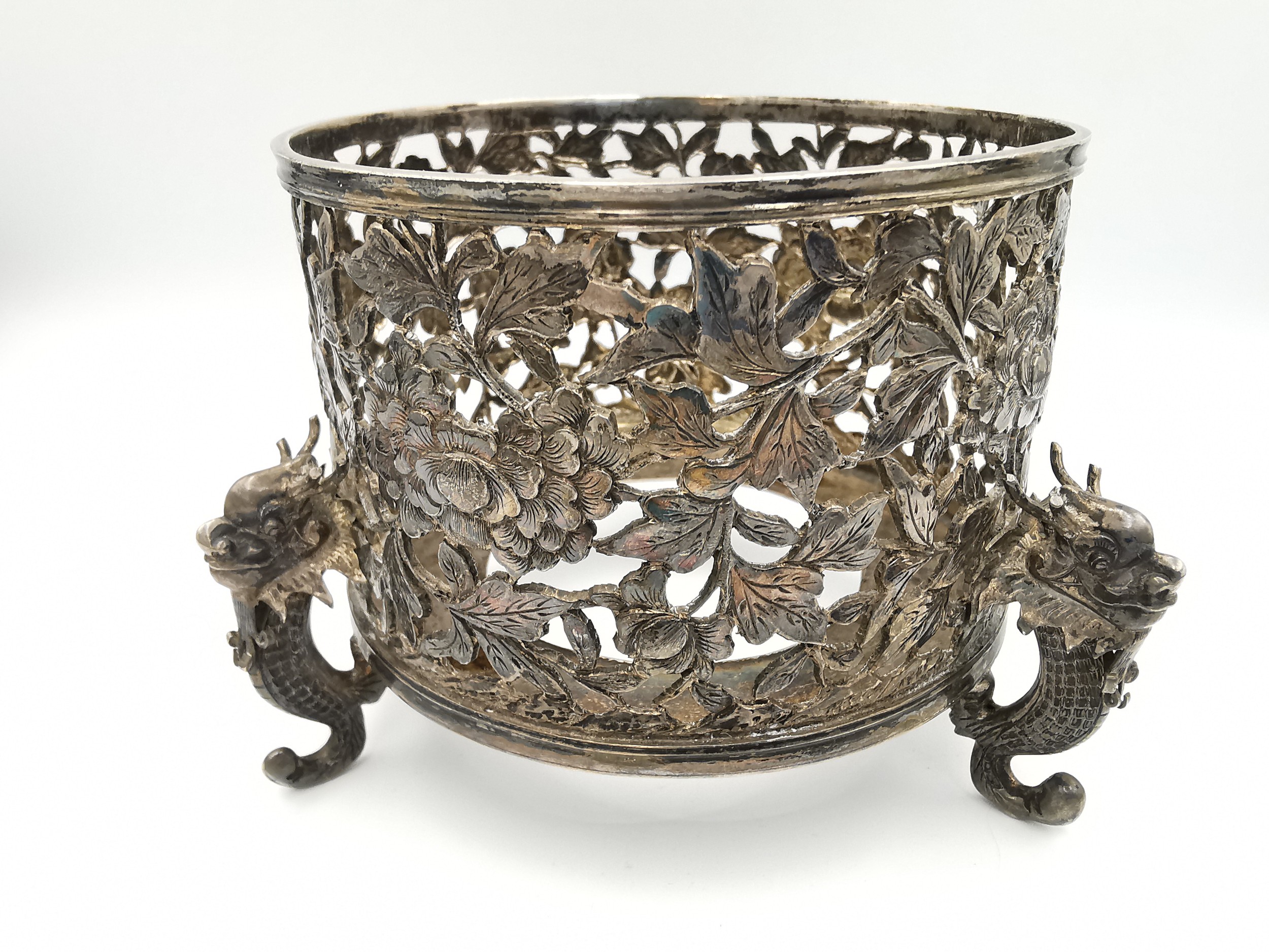 An early 20th century Chinese carved and pierced silver bottle coaster by Wang Hing, decorated