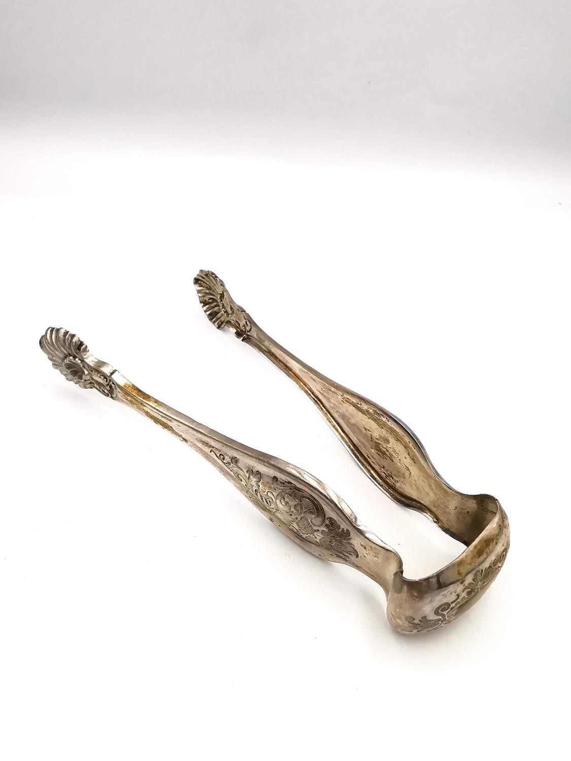 A collection of silver and white metal items, including a pair of sugar tongs with engraved - Image 5 of 16