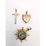 A collection of 9ct gold and rolled gold charms, including a 9ct rose gold shield shape locket, a