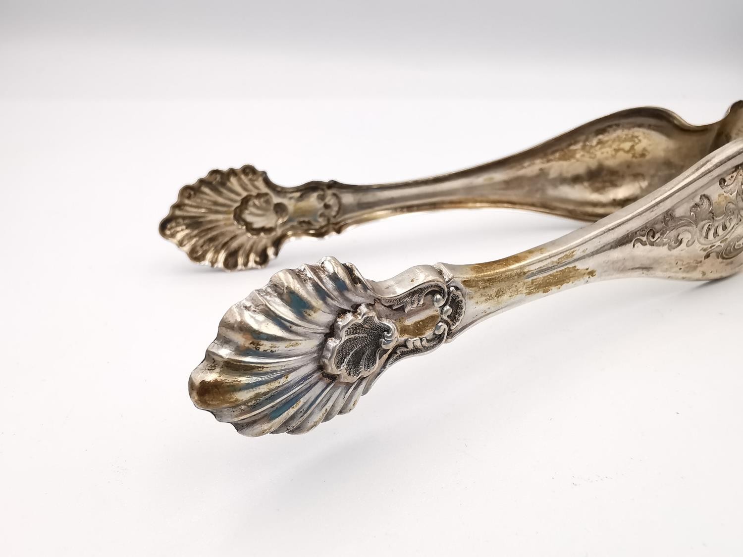 A collection of silver and white metal items, including a pair of sugar tongs with engraved - Image 6 of 16