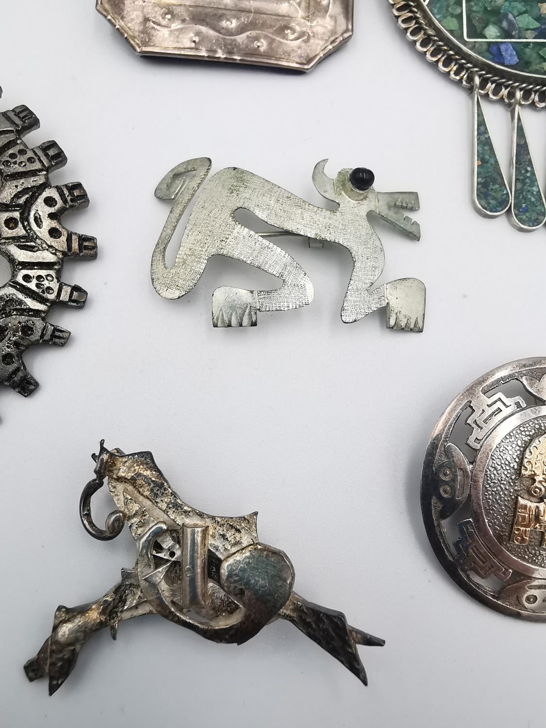 A large collection of silver and white metal Mexican, Mayan and Aztec design brooches, pendants - Image 6 of 9