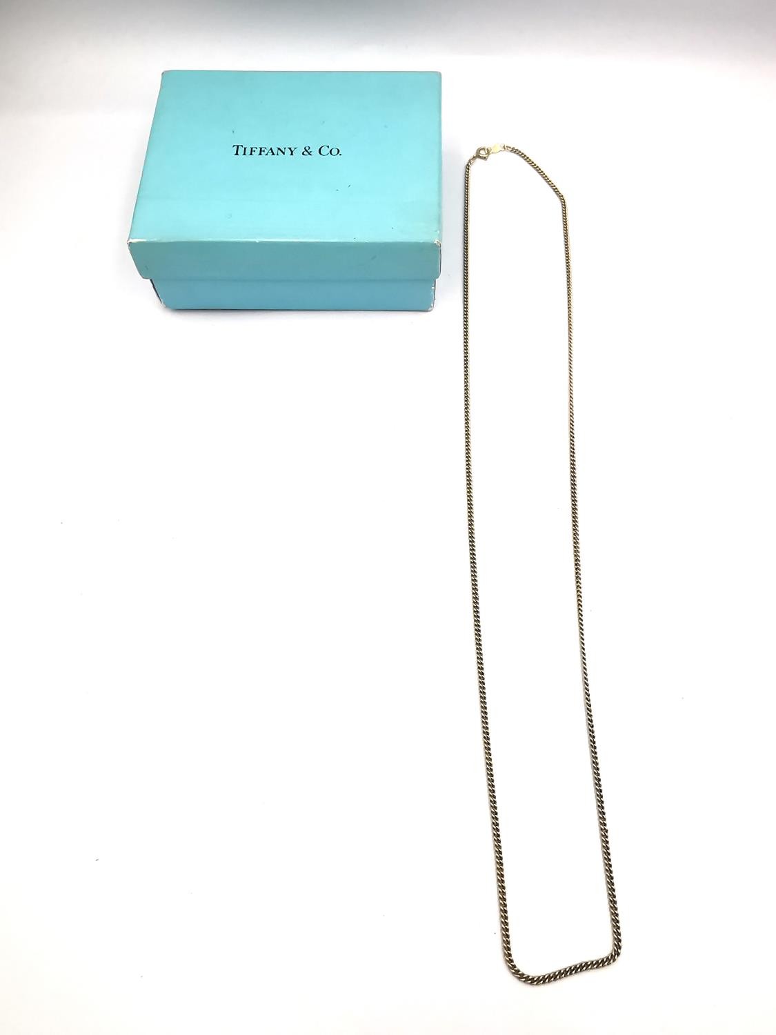 A boxed Tiffany and Co 14 carat 22 inch curb link gold chain with C-sprung clasp. Stamped T&Co, 14K.